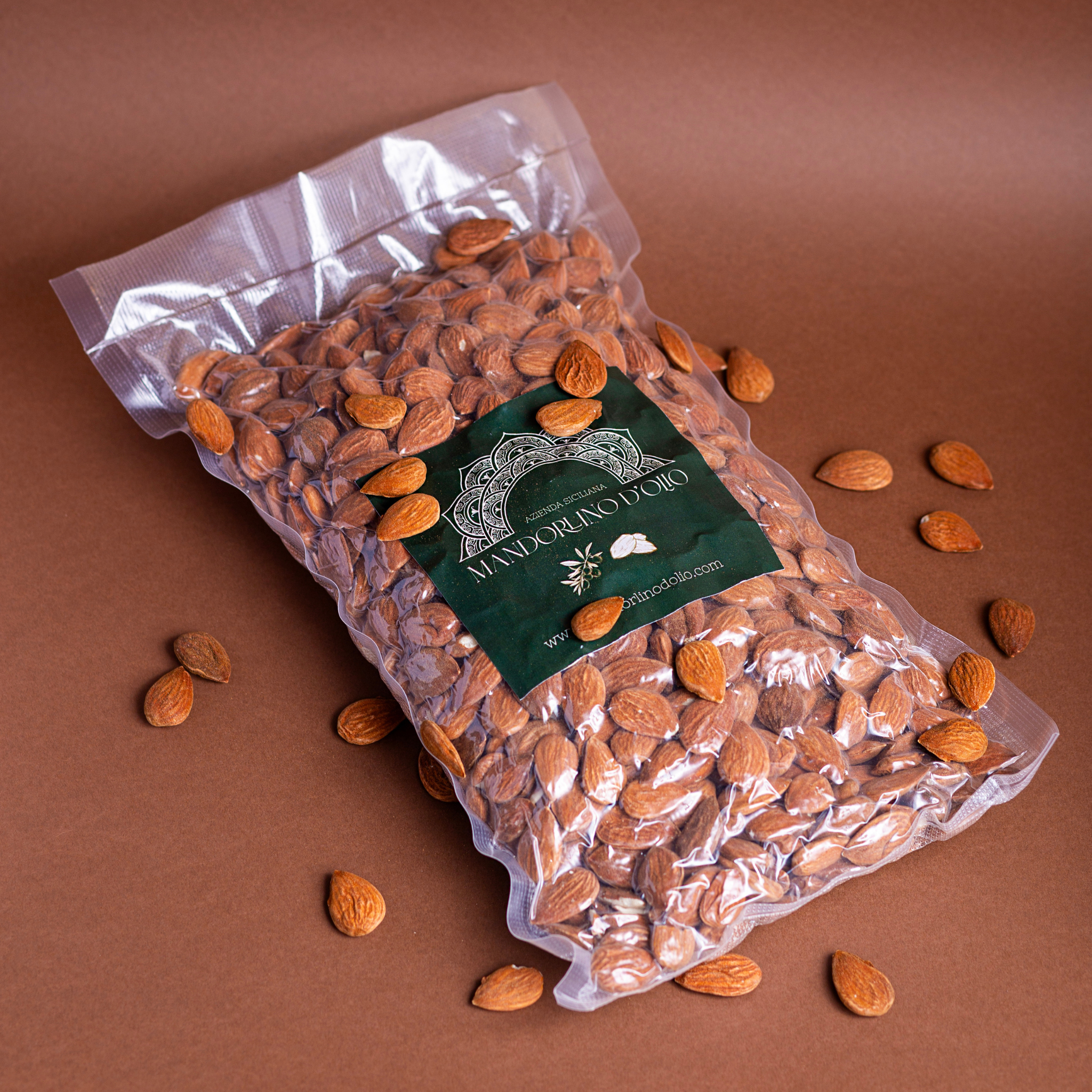 Shelled Sicilian almonds in a 1kg bag by Mandorlino d'Olio, showcasing a rustic packaging design.