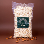 Sicilian blanched almonds in a 1 kg bag by Mandorlino d'olio, showcasing the product's natural texture and color.